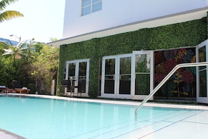 Una piscina al aire libre, sillones reclinables de piscina