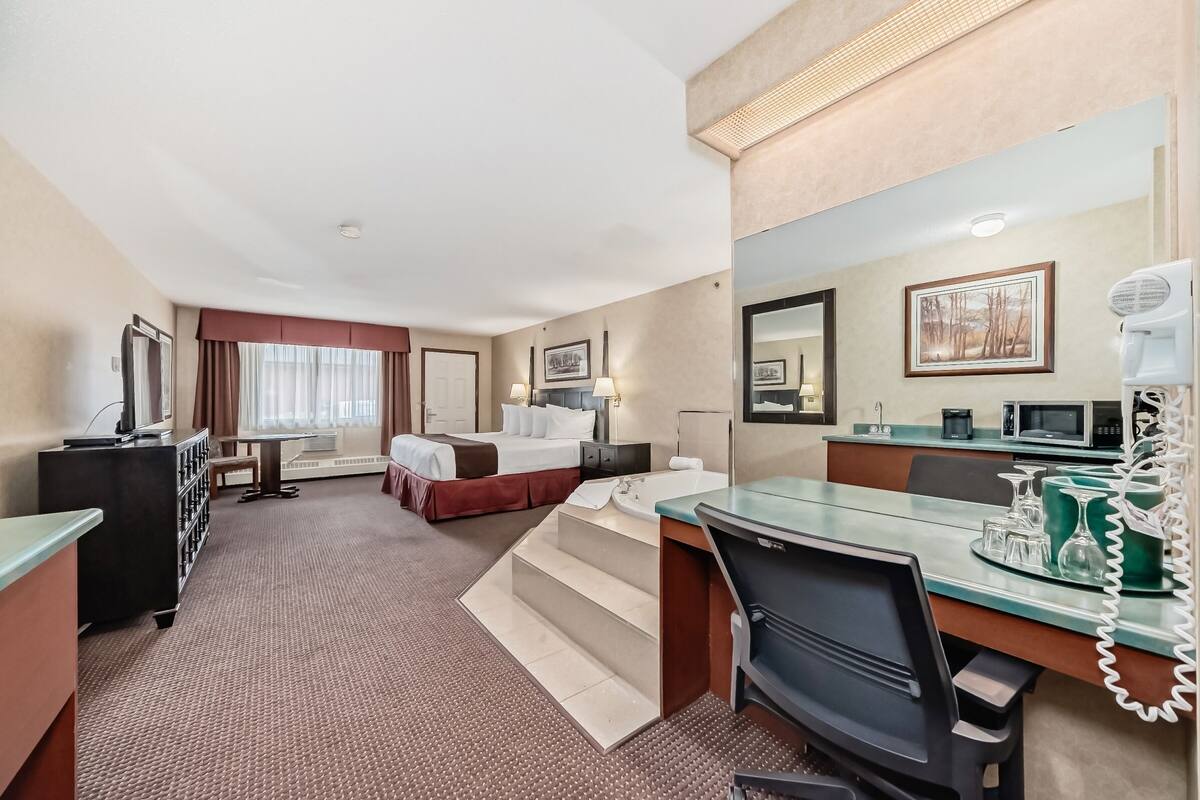 Une chambre d’hôtel équipée d’un lit, d’un bureau et d’une kitchenette.