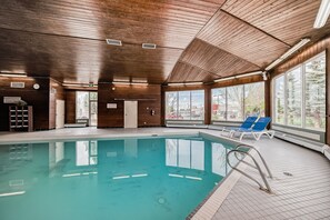 Una piscina techada, sillones reclinables de piscina