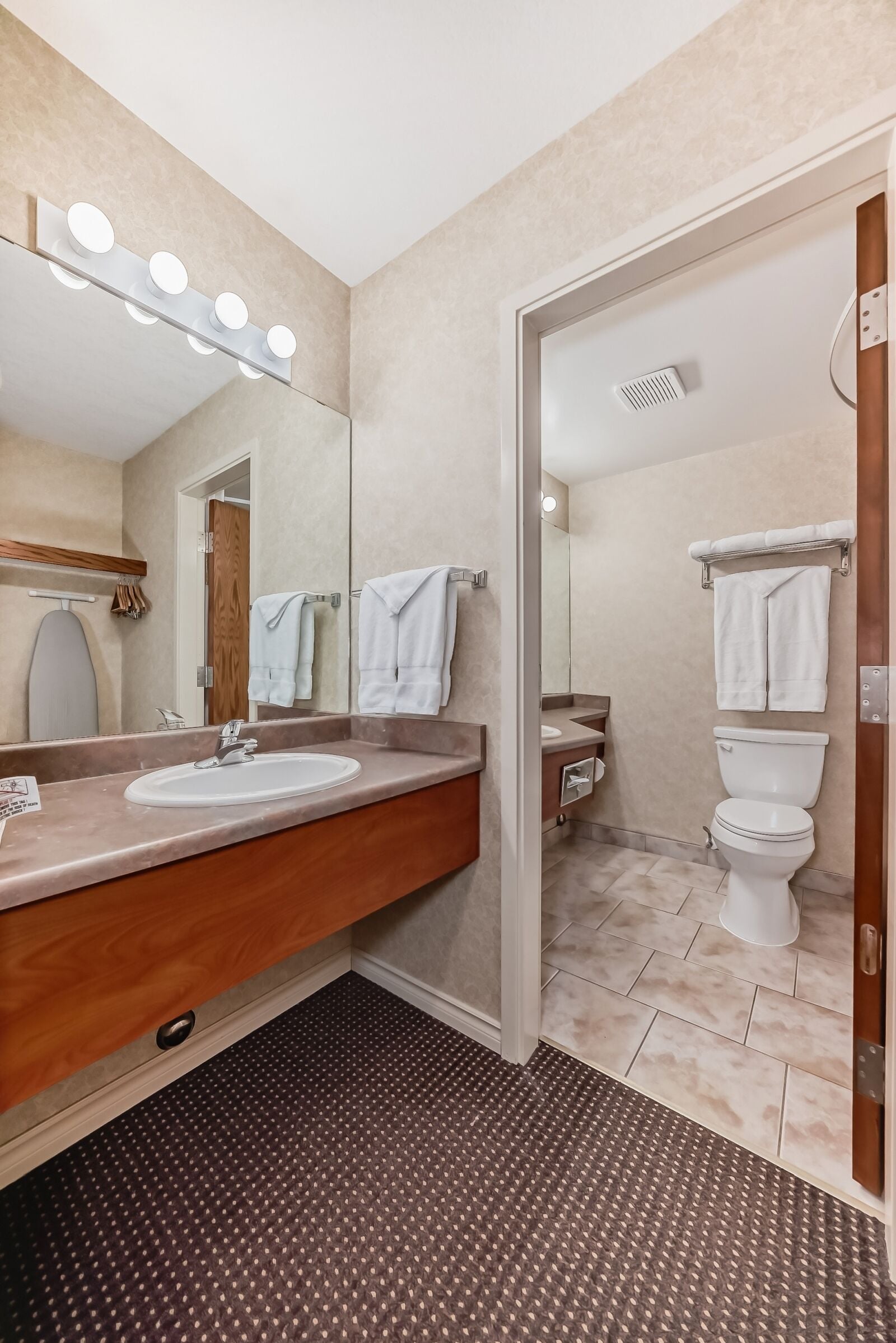 A modern bathroom with a vanity, sink, mirror, and lights.