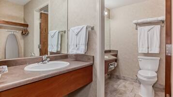 A modern bathroom with a vanity, sink, mirror, and lights.