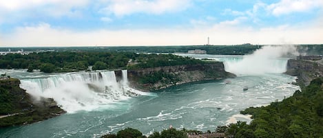 Une grande cascade avec une plateforme d’observation et un bâtiment situé au loin.