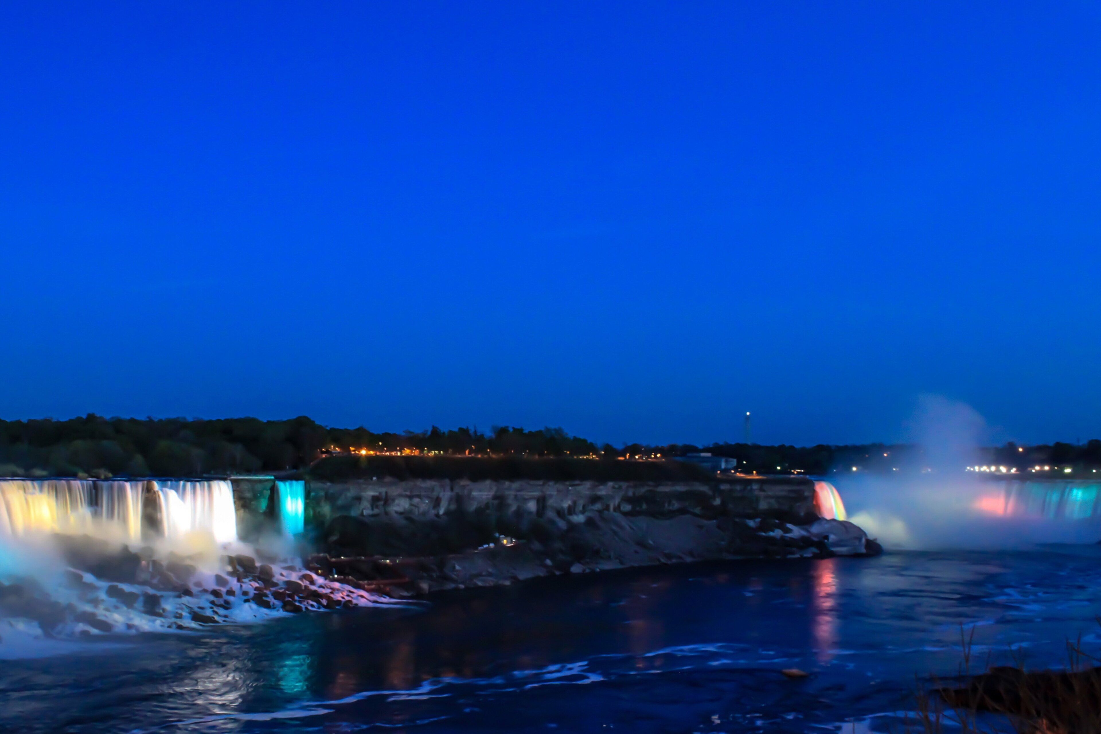 A waterfall with illuminated water features at night.