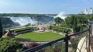On peut admirer une cascade, un parc avec une place circulaire et, au loin, le profil de la ville.