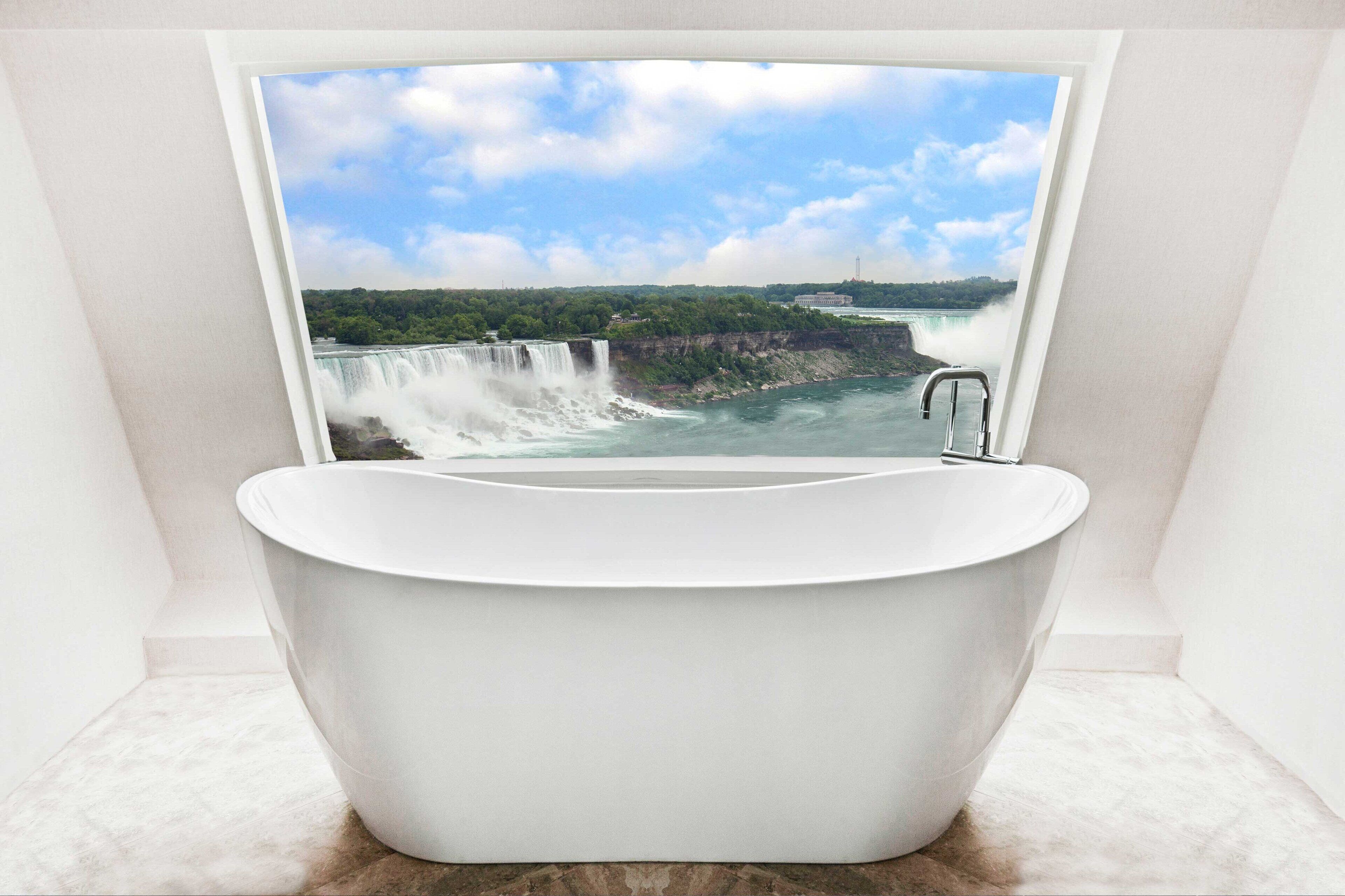 Un baño moderno con una bañera independiente, un ventanal grande y vistas a una cascada.