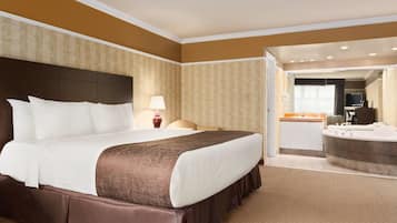 Een hotelkamer met een groot bed, een badkamer met bad en uitzicht op de hotellobby.