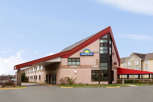 A Days Inn hotel with a red roof, brick facade, and a covered outdoor area.