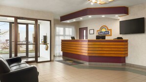 A reception area with a reception desk, a television, and a large window. - Days Inn by Wyndham Trois-Rivieres (Trois-Rivieres)