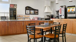 A kitchen with a wooden island, a coffee machine, and a refrigerator. - Days Inn by Wyndham Trois-Rivieres (Trois-Rivieres)
