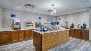 A modern hotel lobby with a central reception desk, a juice bar, and a coffee station. - Best Western Fishers/Indianapolis Area (Fishers)