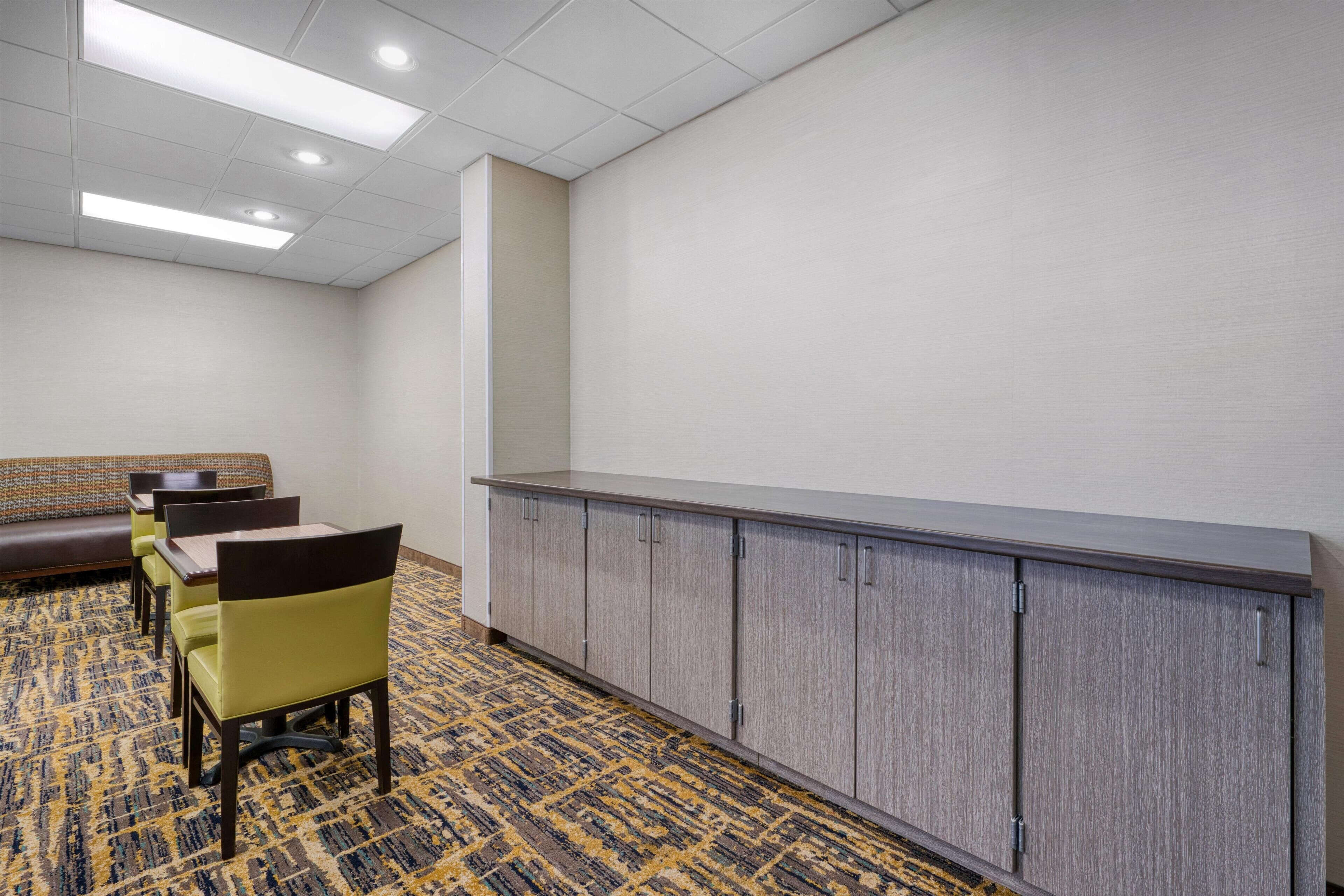 A conference room with a long table, chairs, a sofa, and a cabinet.