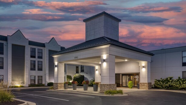 A modern hotel with a covered entrance, a prominent chimney, and a parking lot. - Best Western Fishers/Indianapolis Area (Fishers)