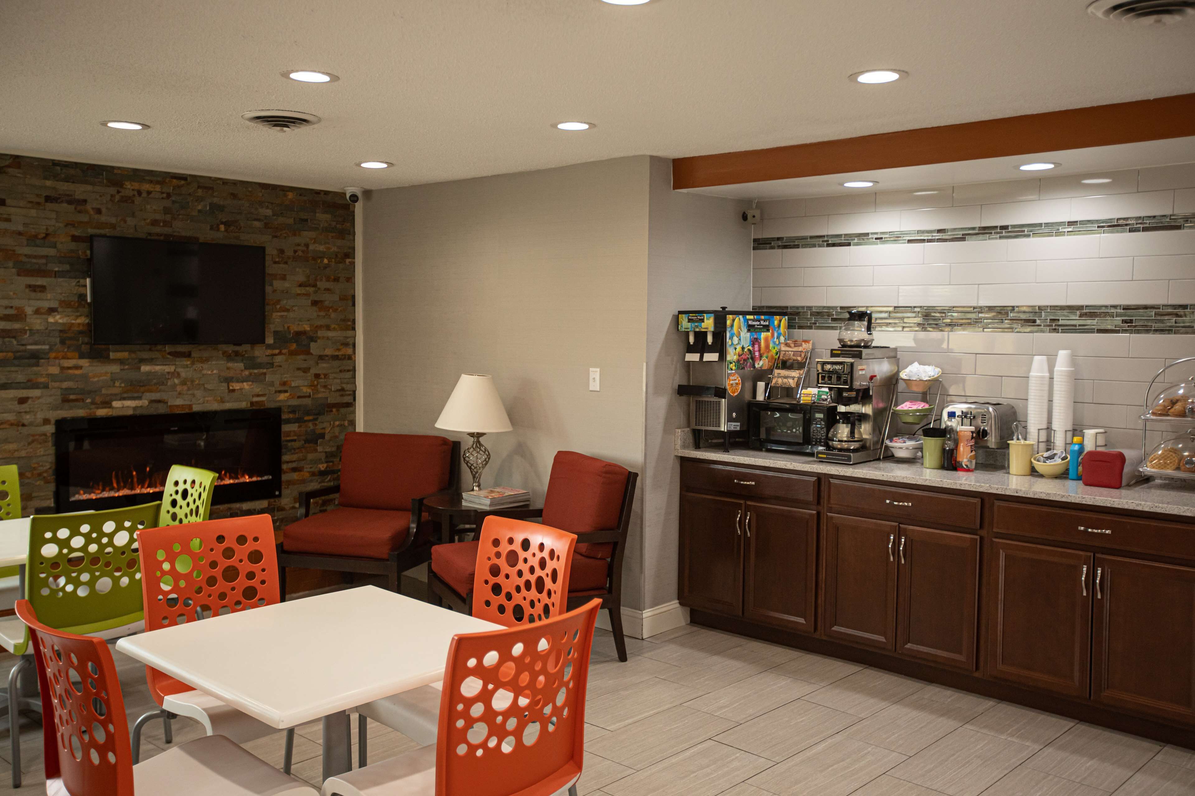 Una cocina moderna con pared de piedra, televisor de pantalla plana y chimenea.