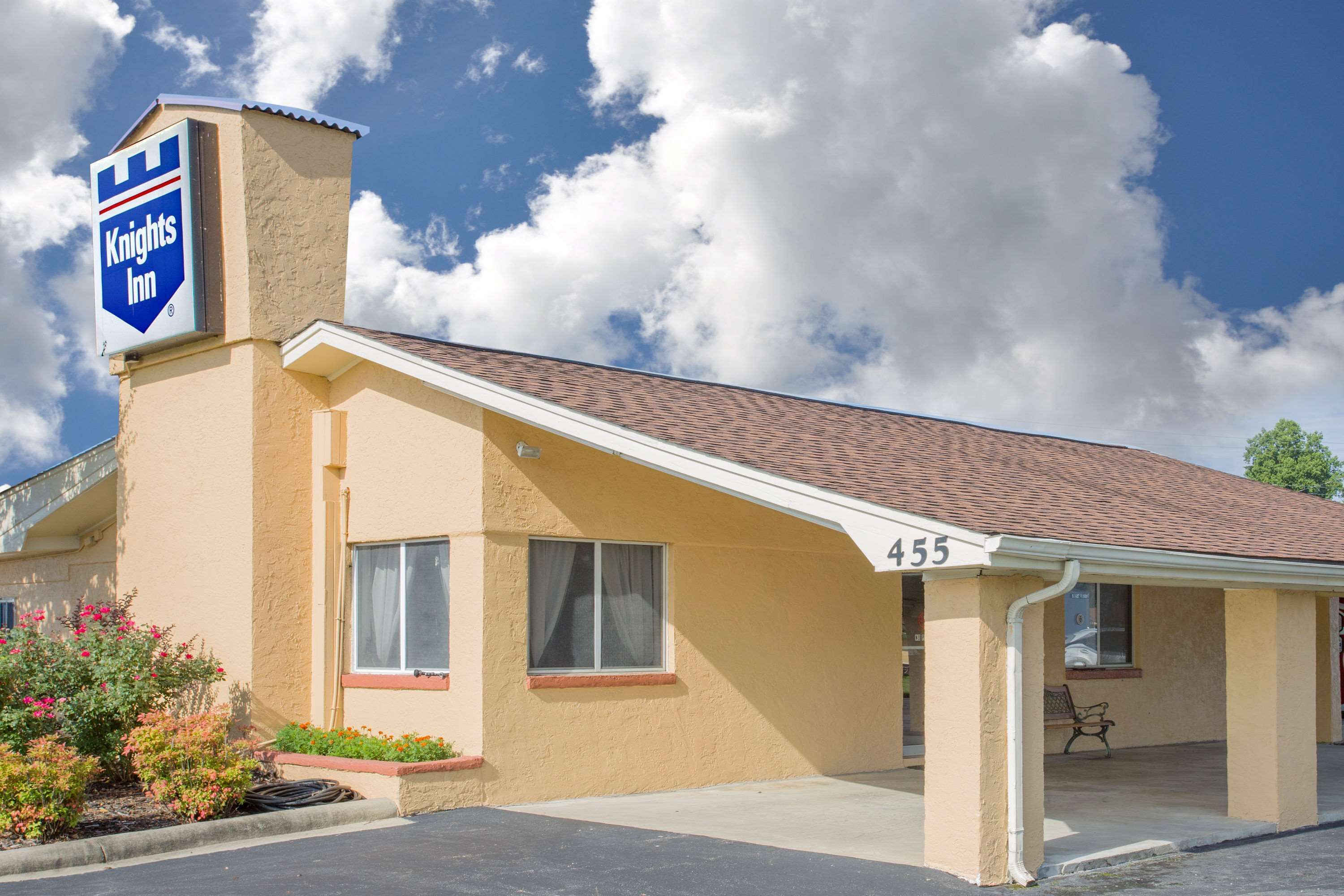 A Knights Inn building with a beige exterior, a covered parking area, and a number 455 sign.