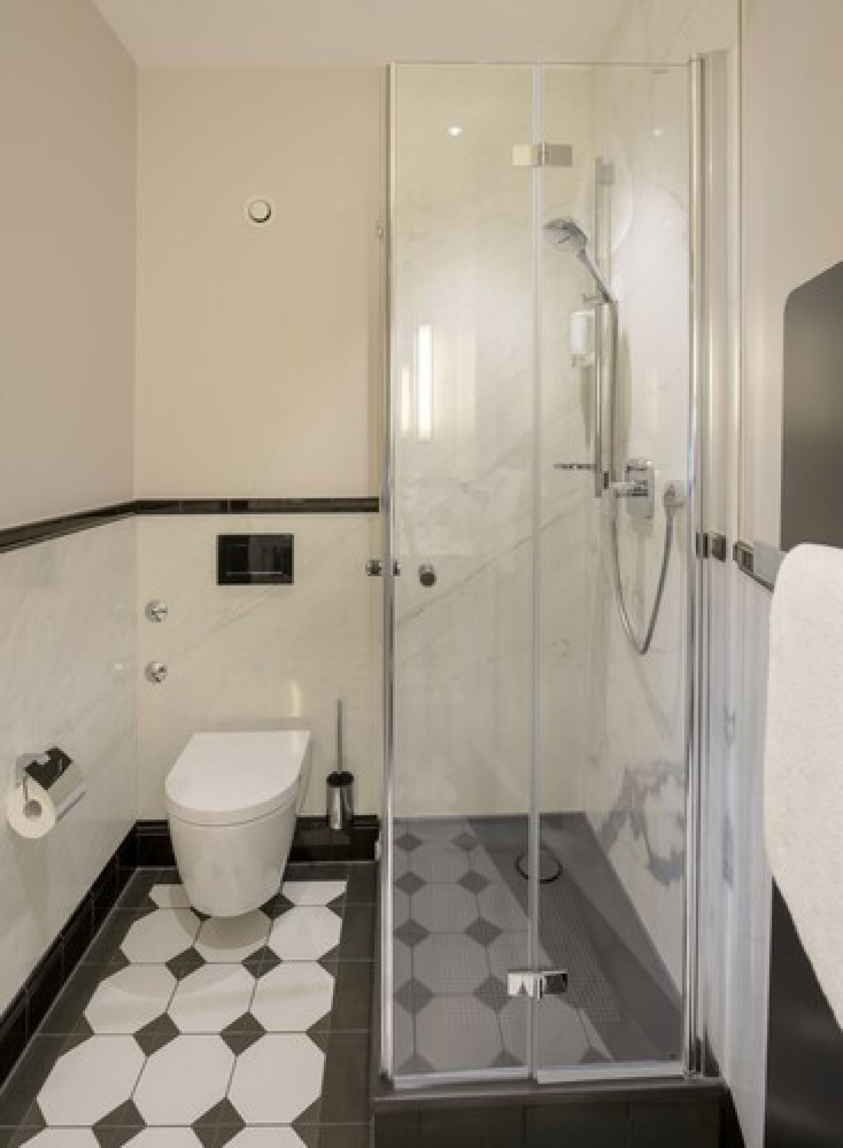 A modern bathroom with a glass-enclosed shower, a toilet, and a sink.