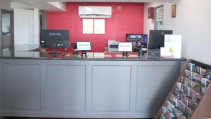 A reception area with a red wall, air conditioning unit, two computers, and a non-smoking sign. - Econo Lodge Franklin South (Franklin)