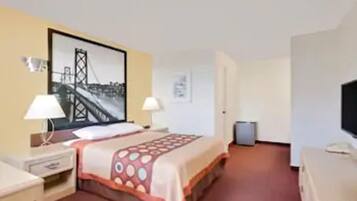 A hotel room with a bed, a desk, a chair, a TV, and a picture of a bridge.