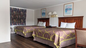 Ein Hotelzimmer mit zwei Betten, Holz Kopfteilen, einem Schreibtisch und einem Stuhl.
