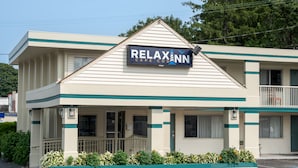 Ein zweistöckiges Motel mit einem Schild, auf dem 'Relax Inn Cape Cod' steht.