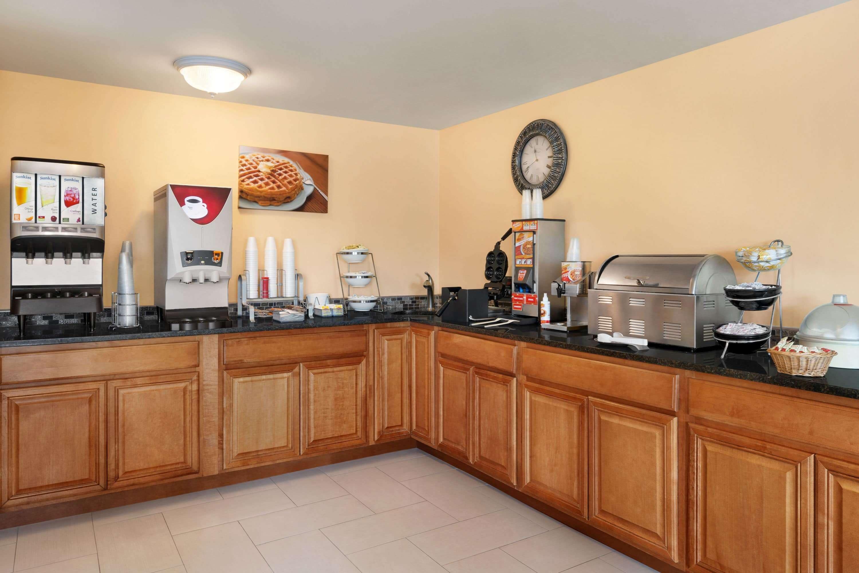 A kitchen with a coffee maker, waffle maker, and toaster.