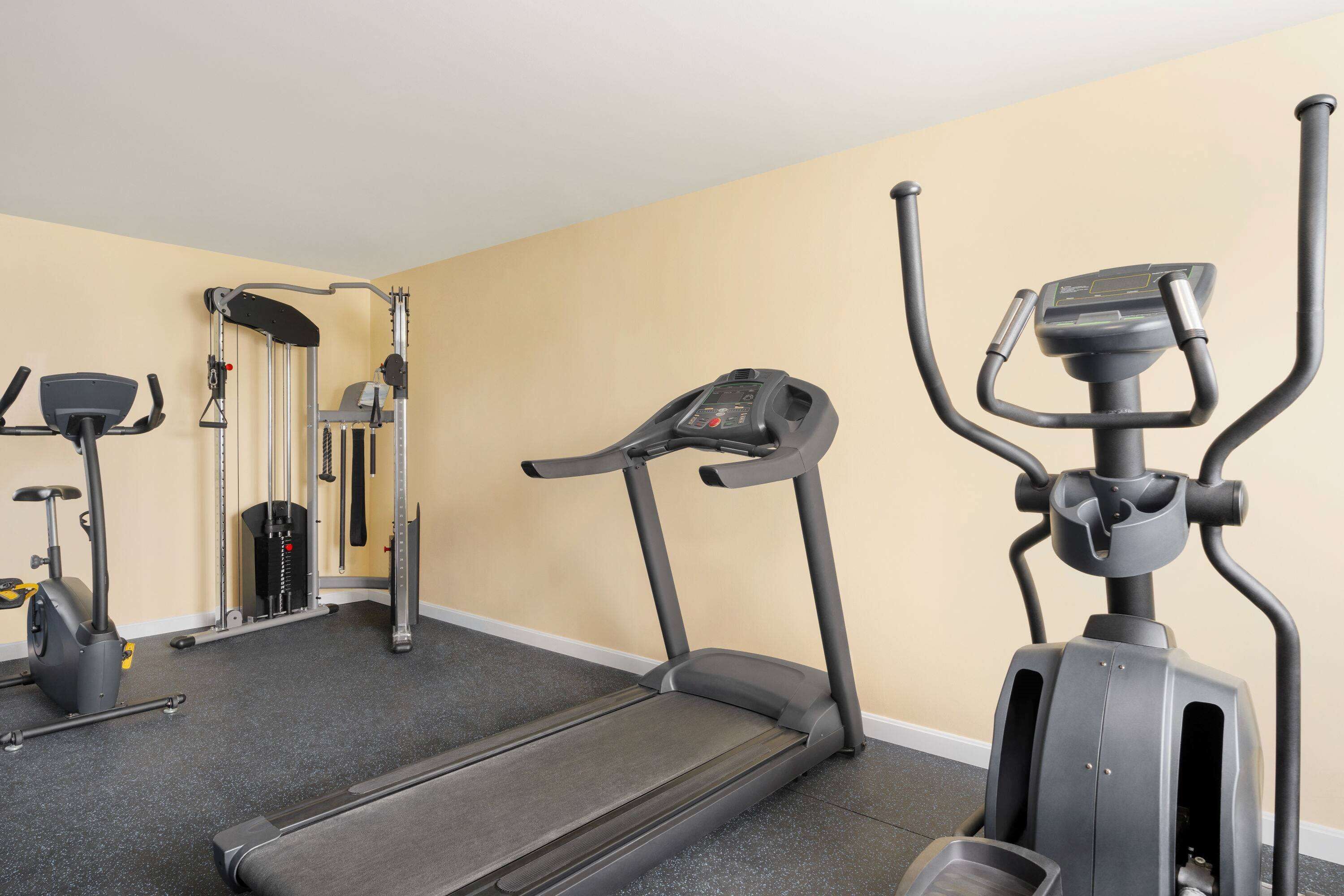 A gym with treadmills, a stationary bike, and a weight machine.