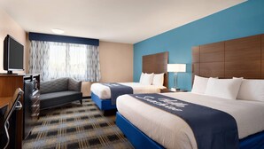 A hotel room with two beds, a desk, a TV, and a window with curtains. - Days Inn by Wyndham Middletown/Newport Area (Middletown)