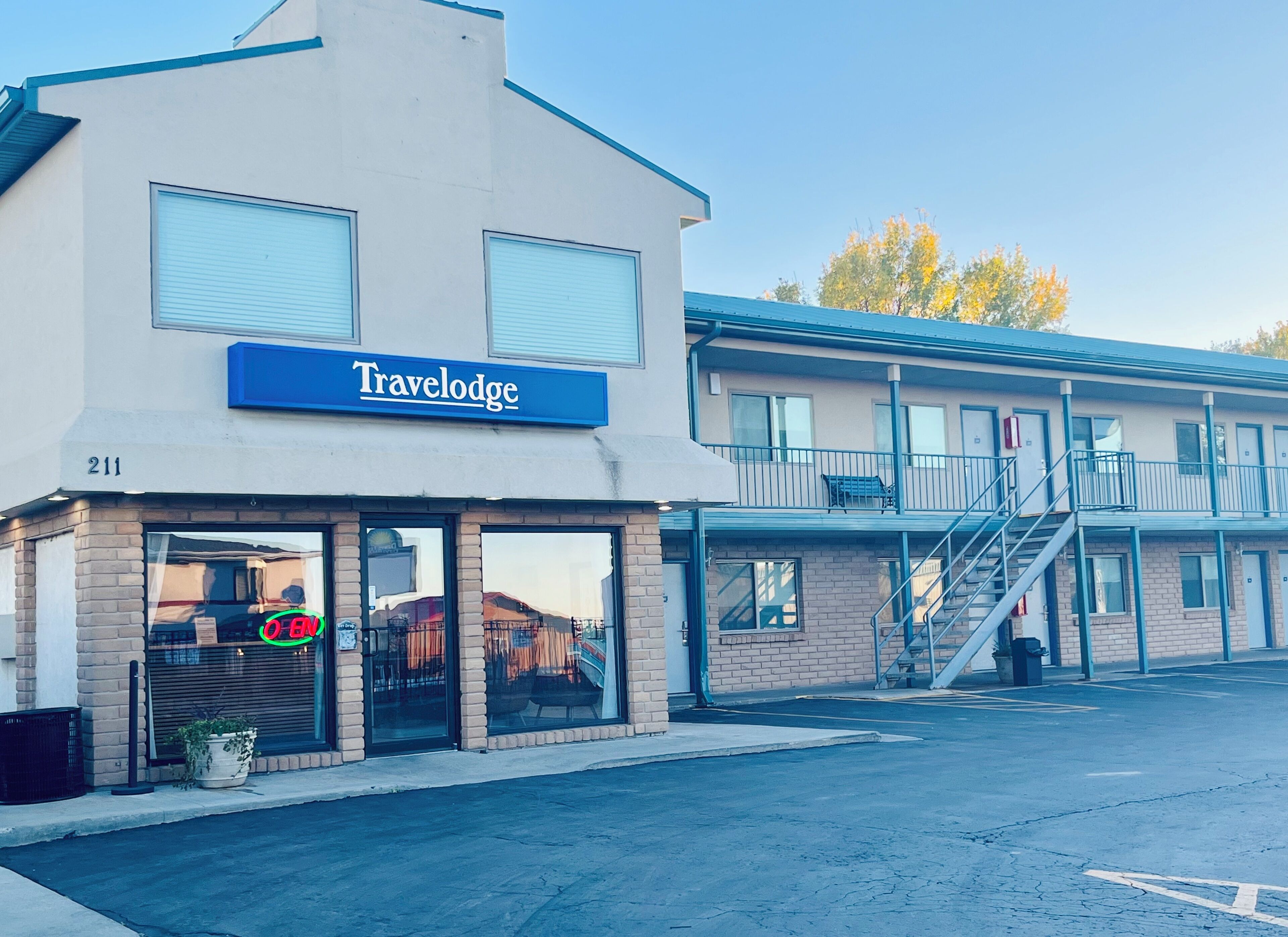 A Travelodge hotel with a blue sign, large windows, and a brick facade.