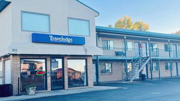 A Travelodge hotel with a blue sign, large windows, and a brick facade.