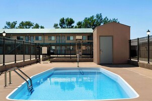 Una piscina al aire libre de temporada, sillones reclinables de piscina