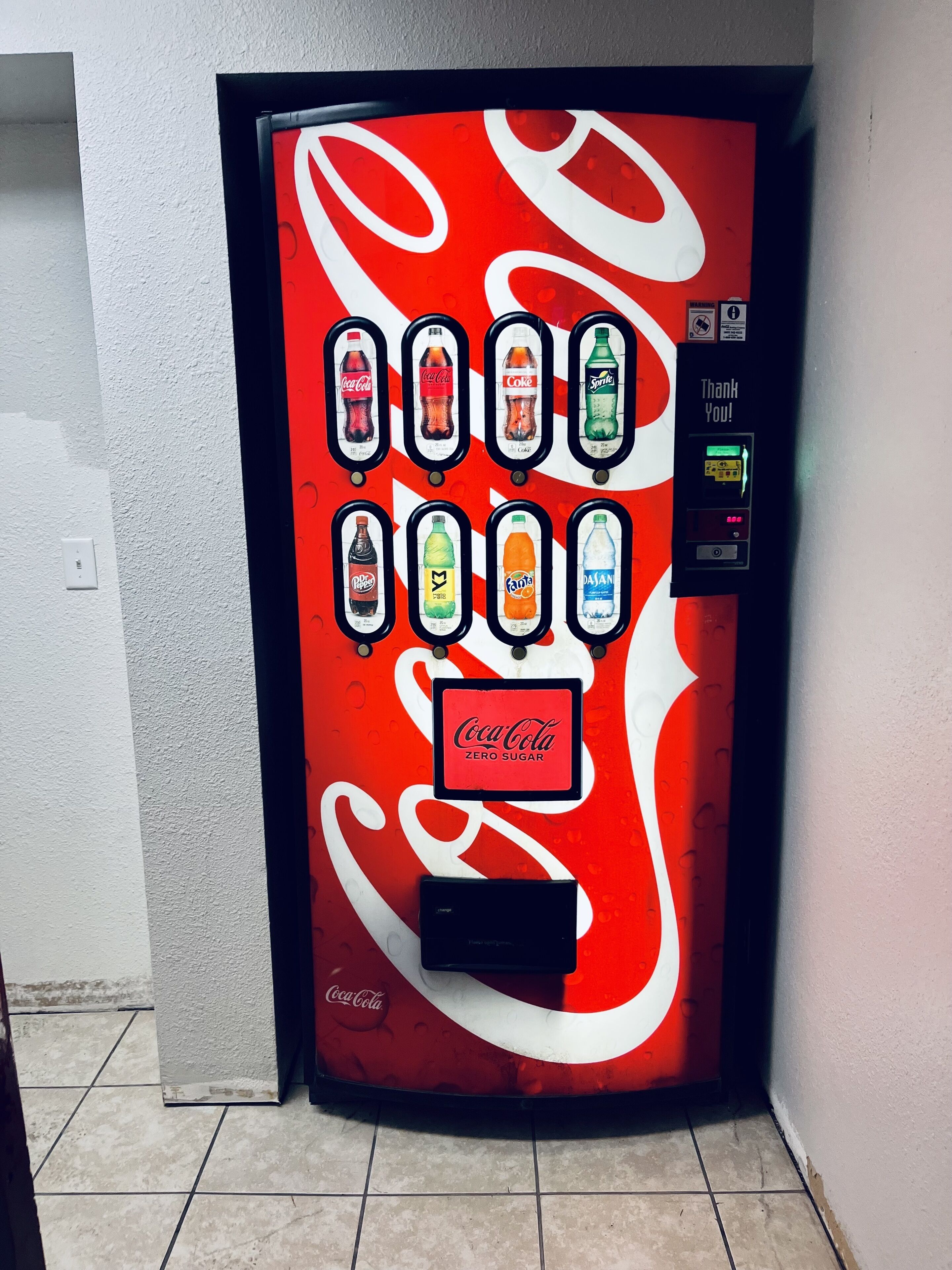 Un distributeur automatique aux couleurs de Coca-Cola proposant une variété de boissons.