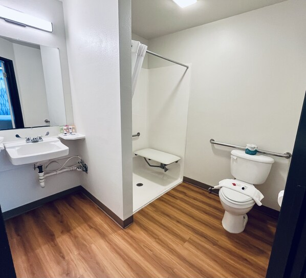 A bathroom with a sink, toilet, and shower.