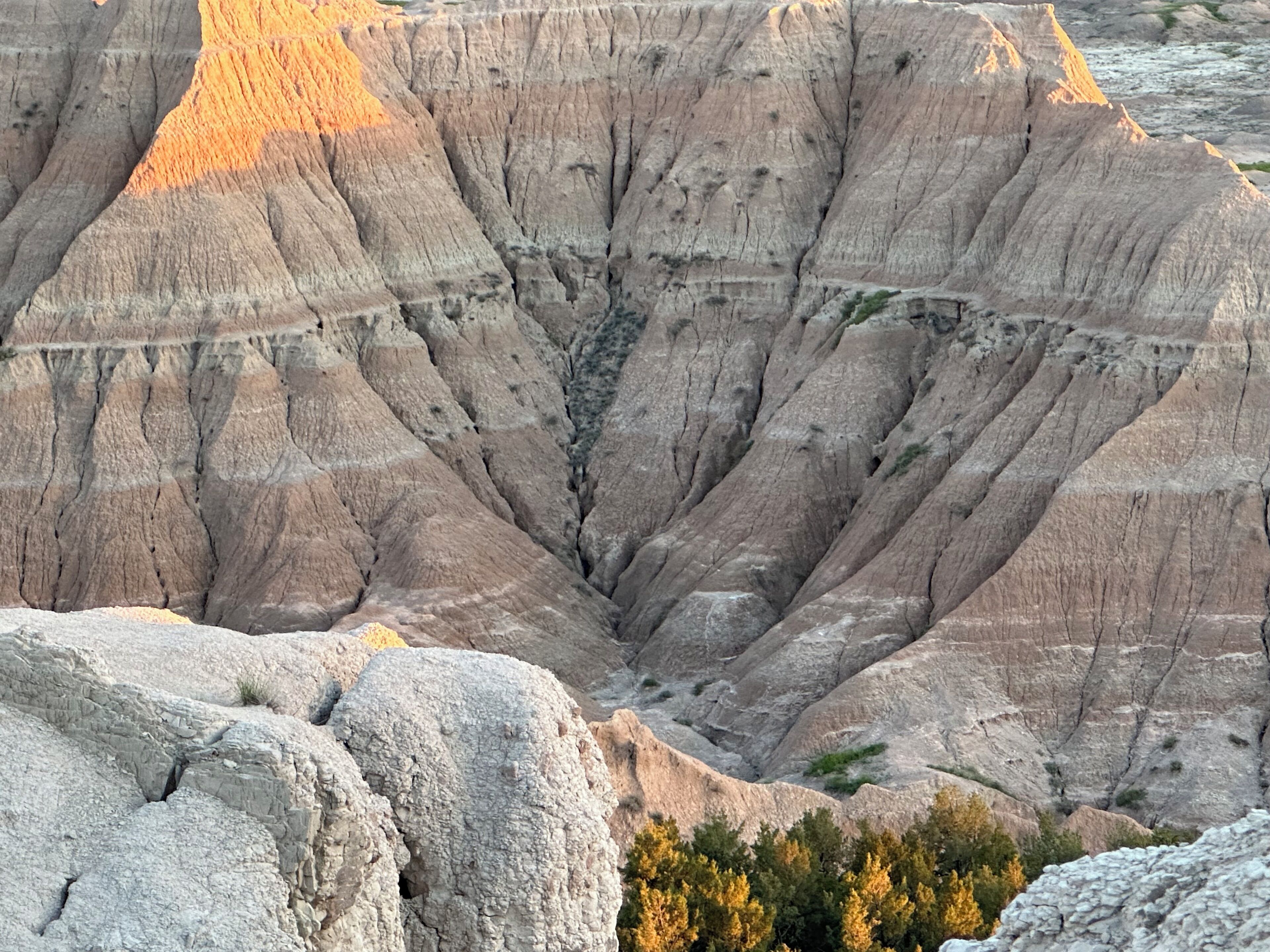 A rugged landscape with layered rock formations and a deep valley.