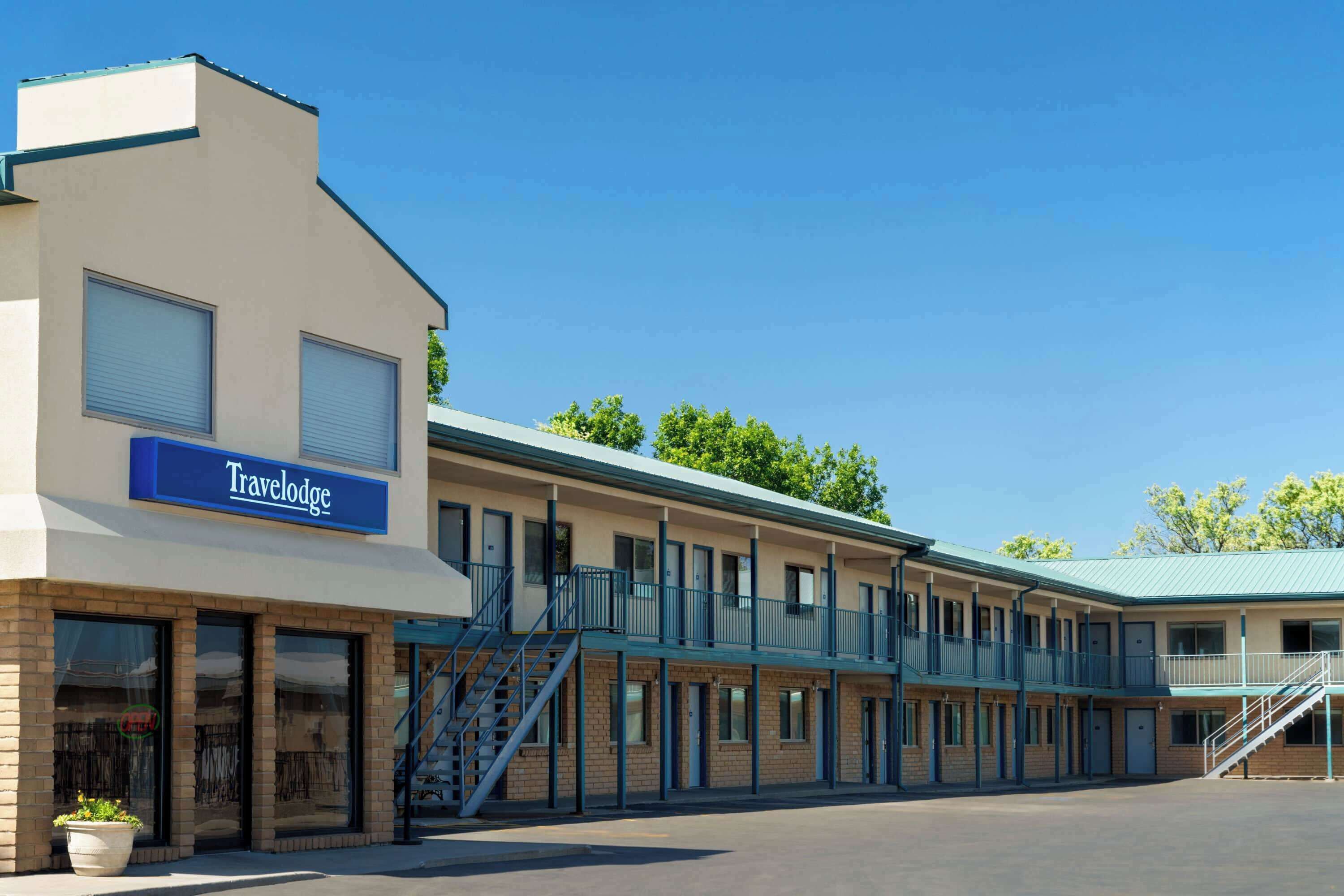 Un motel Travelodge avec un bâtiment à deux étages, de nombreuses chambres et un escalier central.