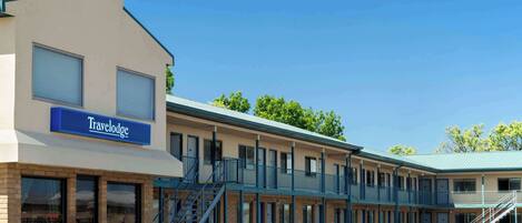 Un motel Travelodge avec un bâtiment à deux étages, de nombreuses chambres et un escalier central.
