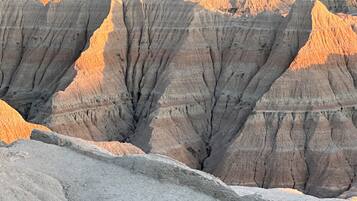 A landscape of rugged, layered rock formations with a valley in the foreground.