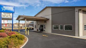 A building with a sign for Ameris Best Value Inn, featuring amenities like a pool and internet. - Americas Best Value Inn Burns (Burns)