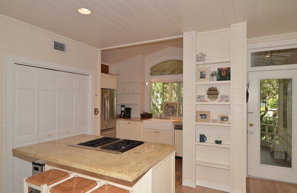 A kitchen with white cabinetry, a granite countertop, and a built-in stove.