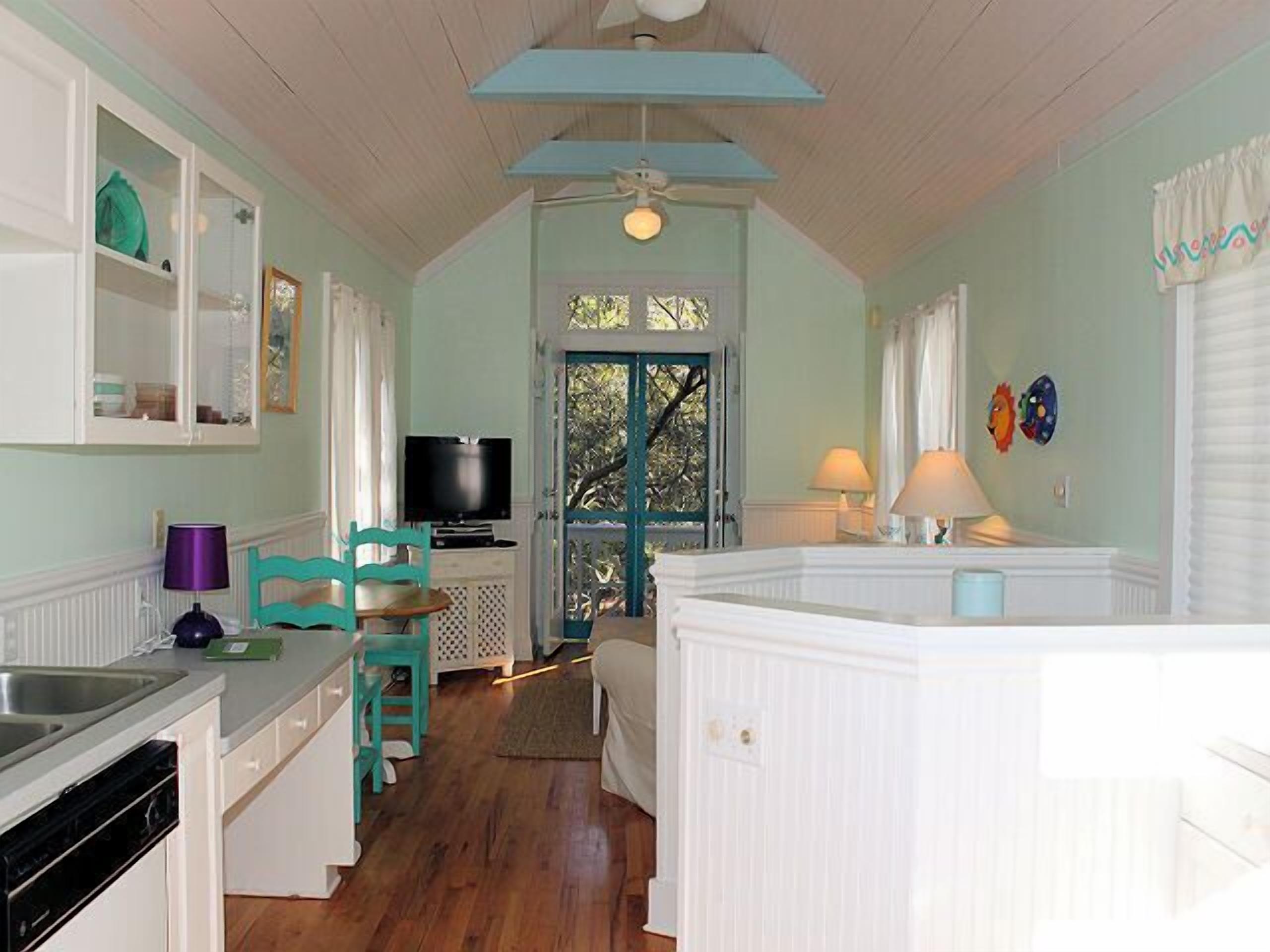 A compact kitchen with a dining area, a television, and a window with a view.