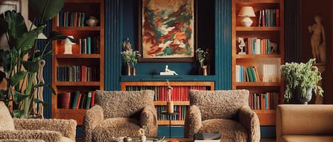 A cozy living room with a fireplace, bookshelves, and comfortable seating.