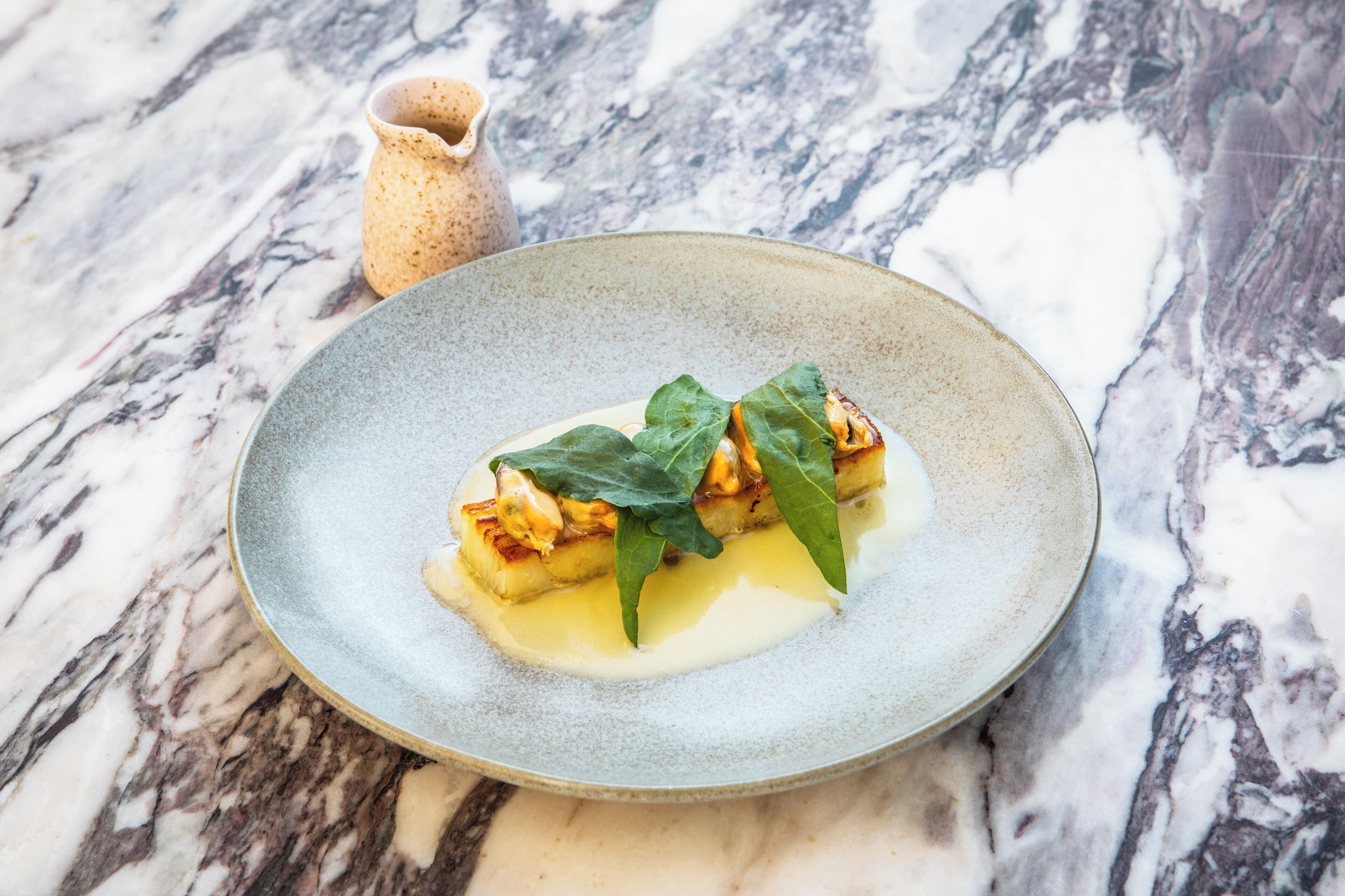 A dessert on a plate with a marble background.