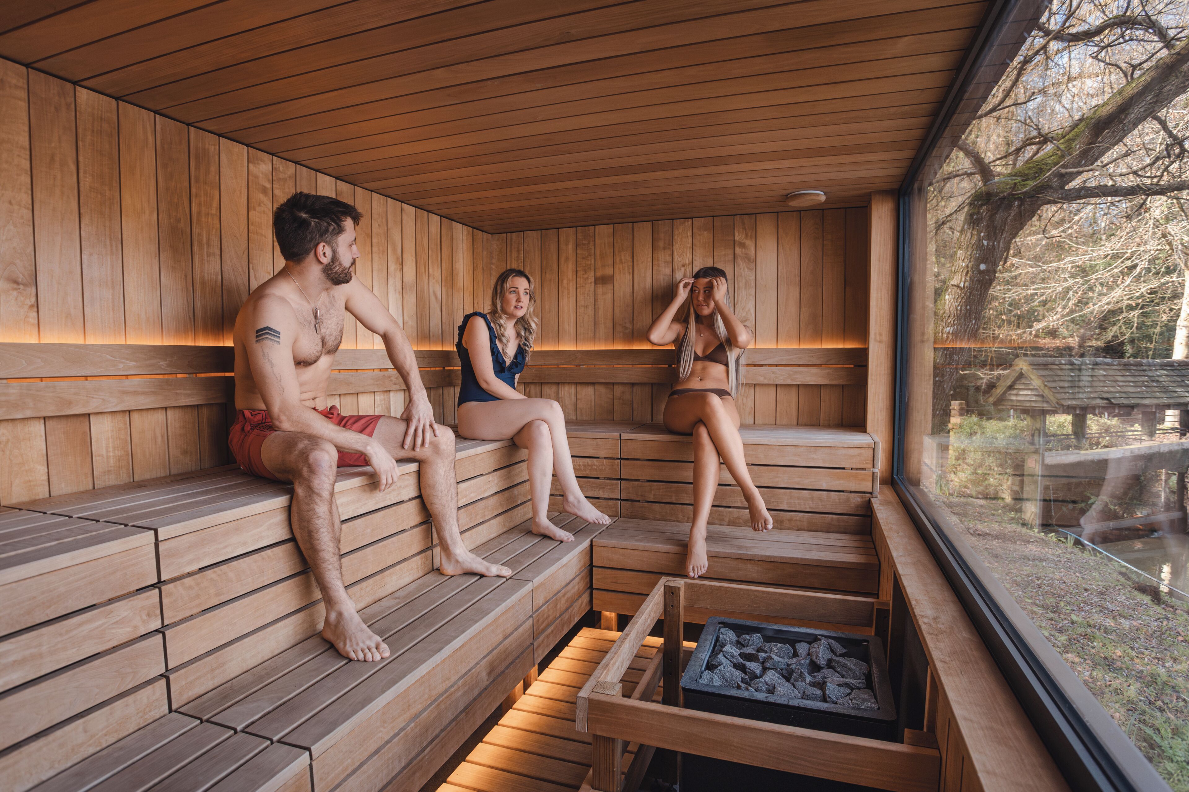 A sauna with wooden benches and a stone basin.