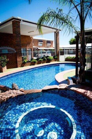 A swimming pool with a tiled edge and a hot tub in the center. - The Charles Sturt Motor Inn (Cobram)