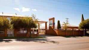 A brick building with a covered entrance and a signboard.