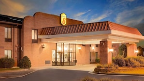 Un hotel con fachada de ladrillo, un letrero de 'Super 8' y un acceso cubierto con puerta de vidrio.