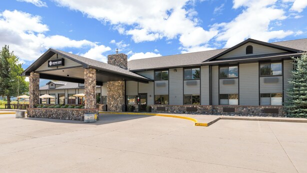 A hotel with a stone facade, a covered entrance, and a clear sky. - MTN Lodge Ridgway (Ridgway)