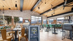 A spacious restaurant with wooden ceilings and large windows offering mountain views. Tables and chairs are arranged for dining. - MTN Lodge Ridgway (Ridgway)
