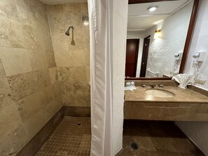 A bathroom with a shower, a sink, and a mirror.