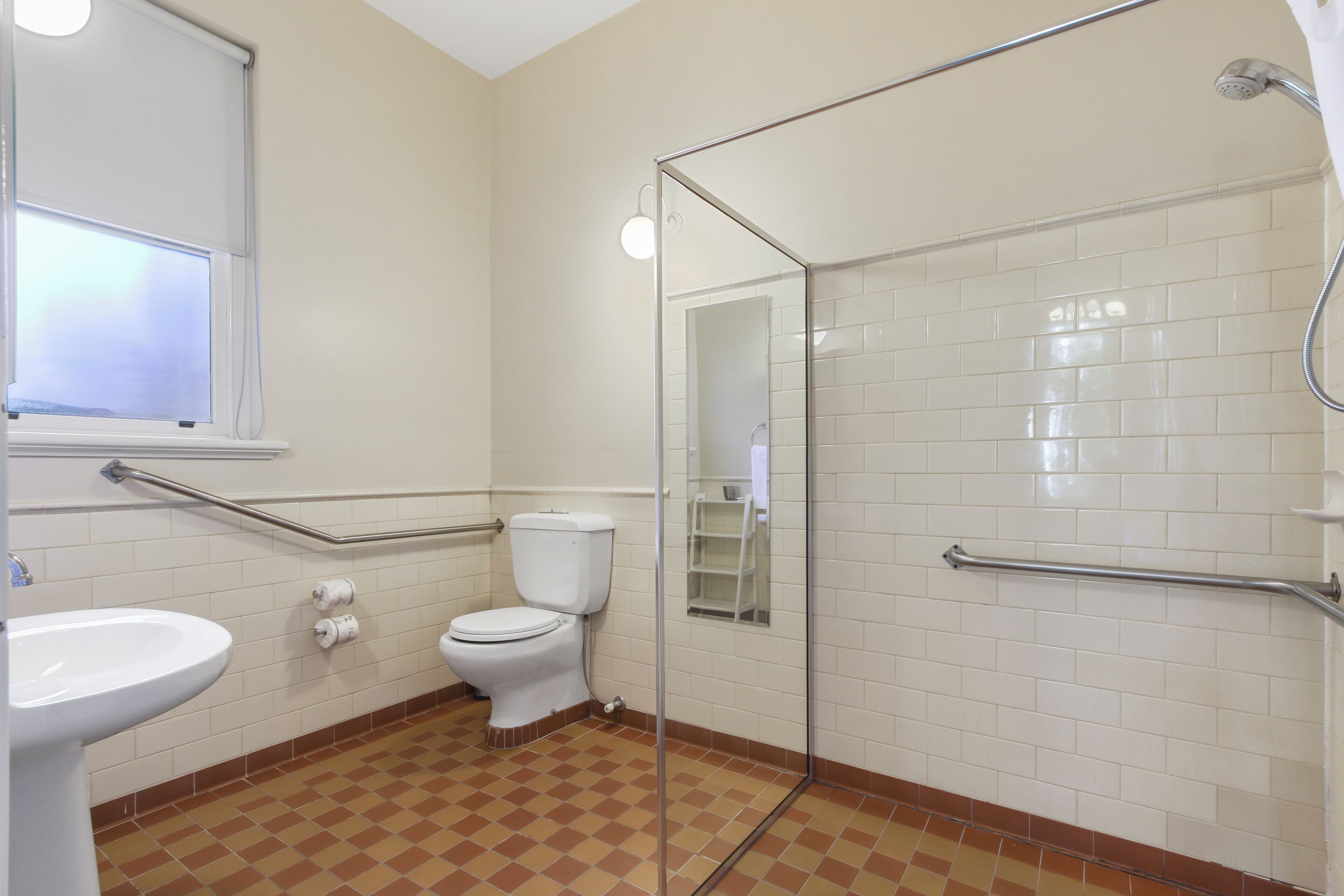 Ein Badezimmer mit Toilette, Waschbecken und Duschkabine aus Glas.