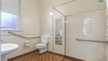 Ein Badezimmer mit Toilette, Waschbecken und Duschkabine aus Glas.