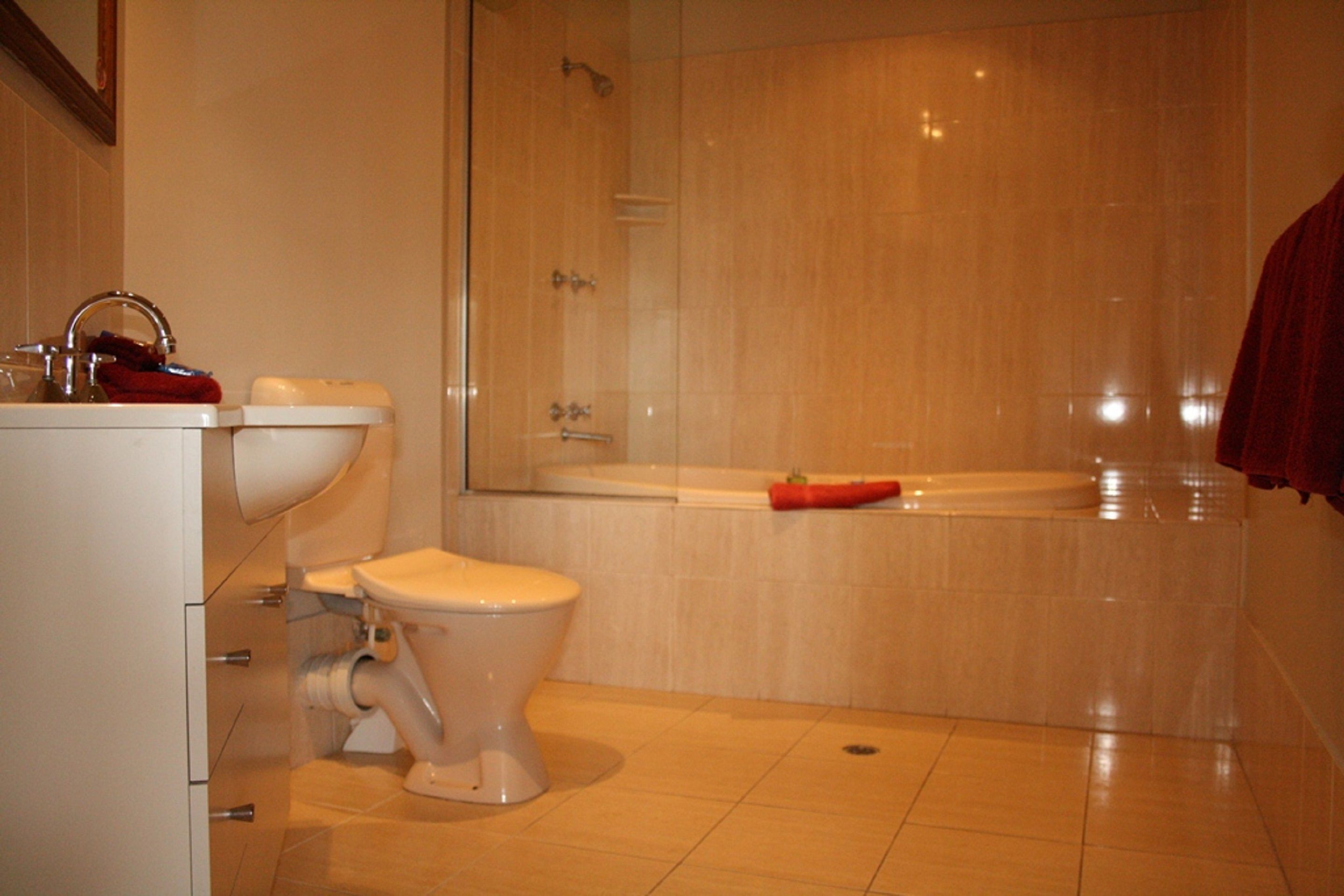 A modern bathroom with a toilet, sink, and shower area.